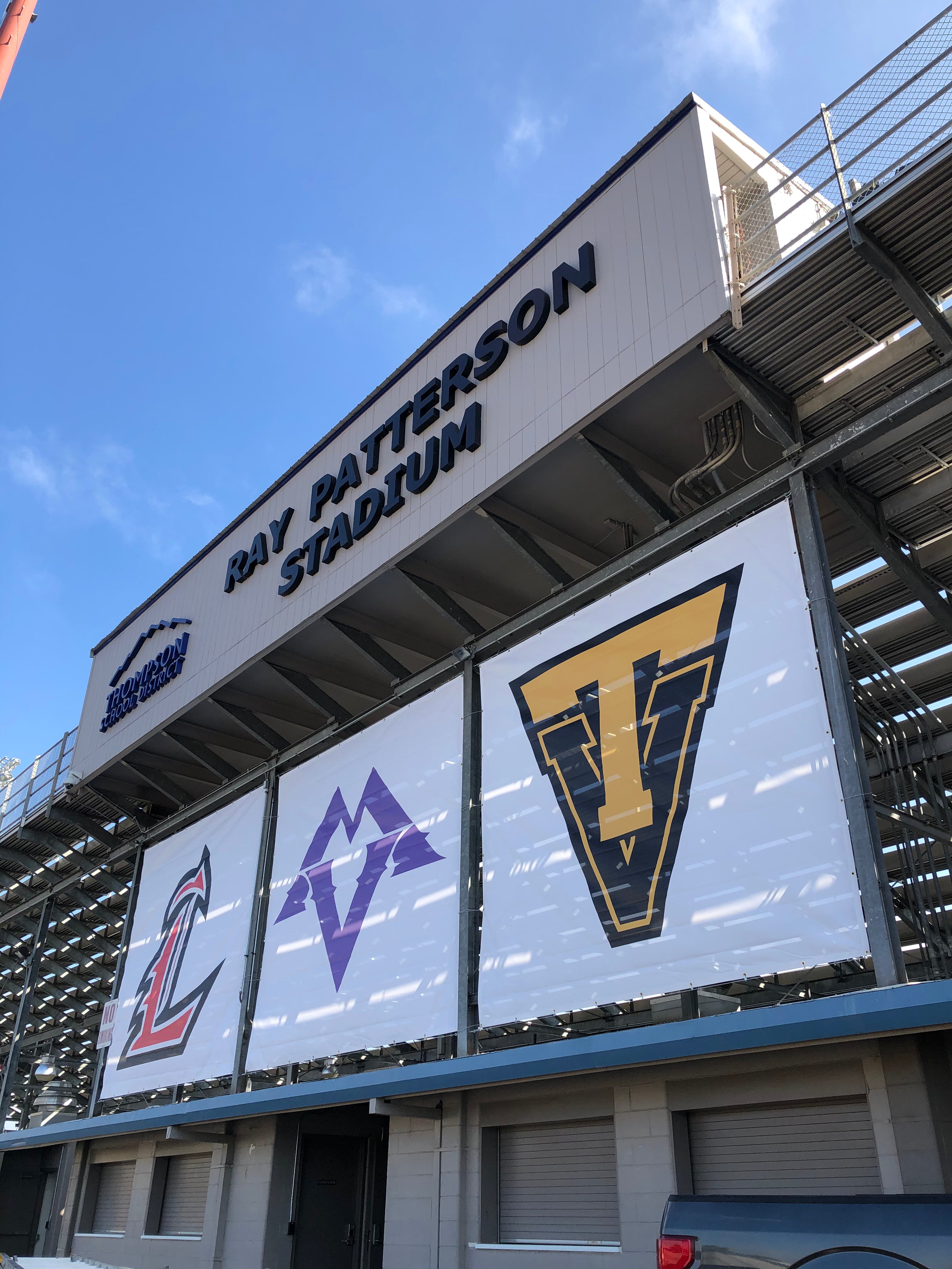 Vinyl banners on the side of a stadium, showcasing the three teams that utilize the field.