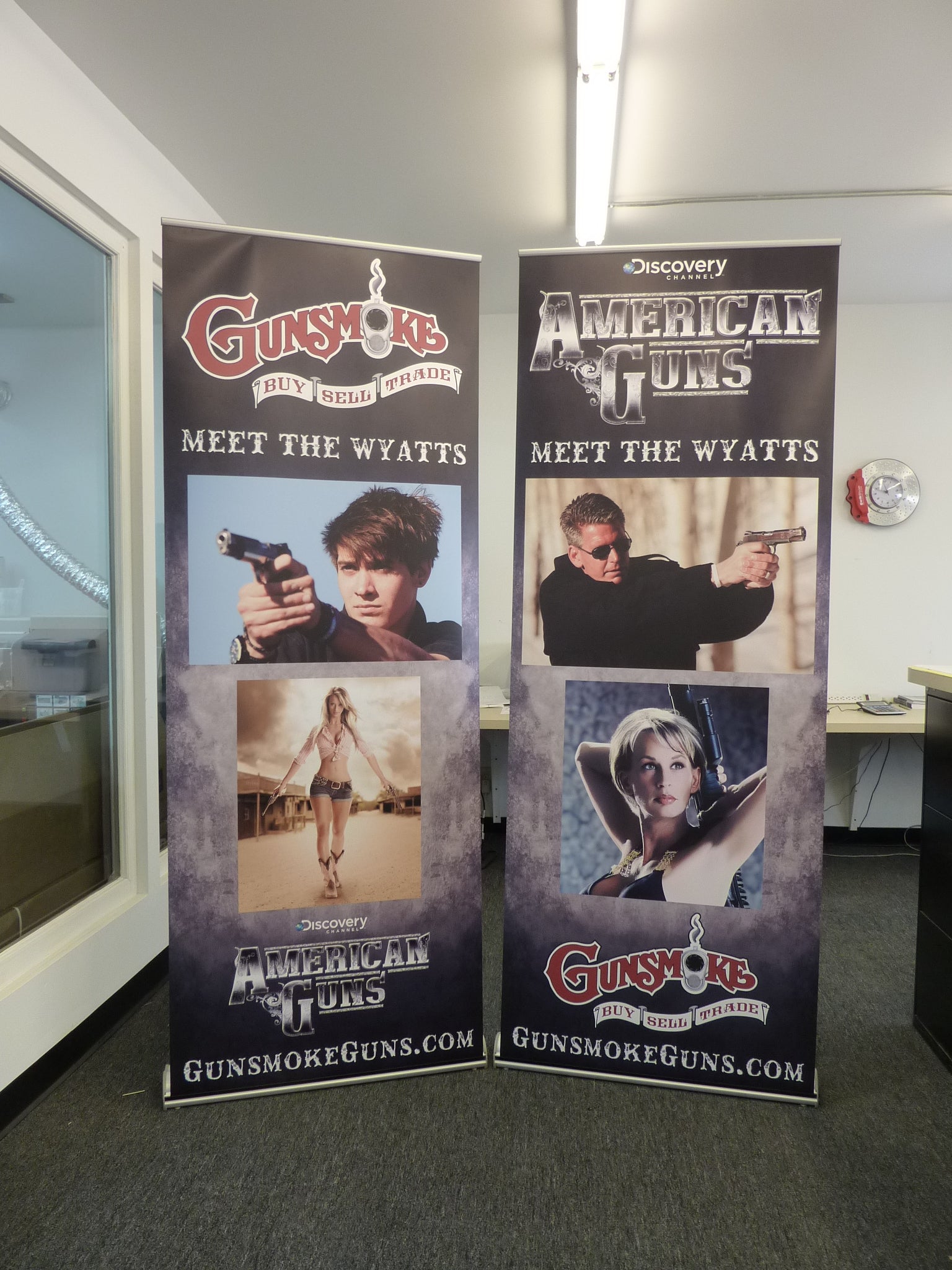 Two retractable banners for Gunsmoke Guns in Wheat Ridge, Colorado, displaying promotional content in a portable format.