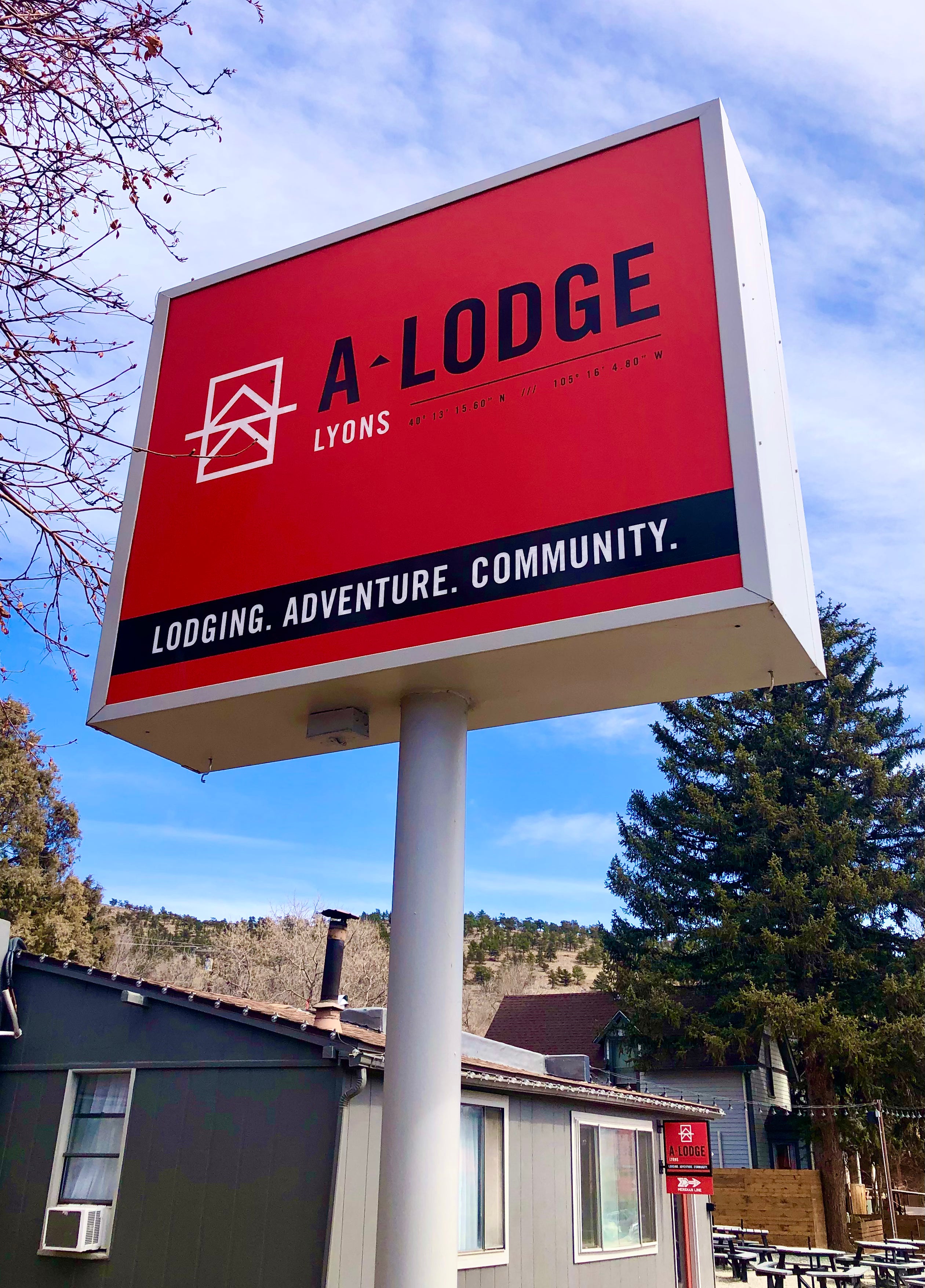 A simple, yet custom outdoor business pole sign for "A-Lodge" in Lyons, Colorado. Featuring a modern, metallic trim with a red background to make their logo and name pop.