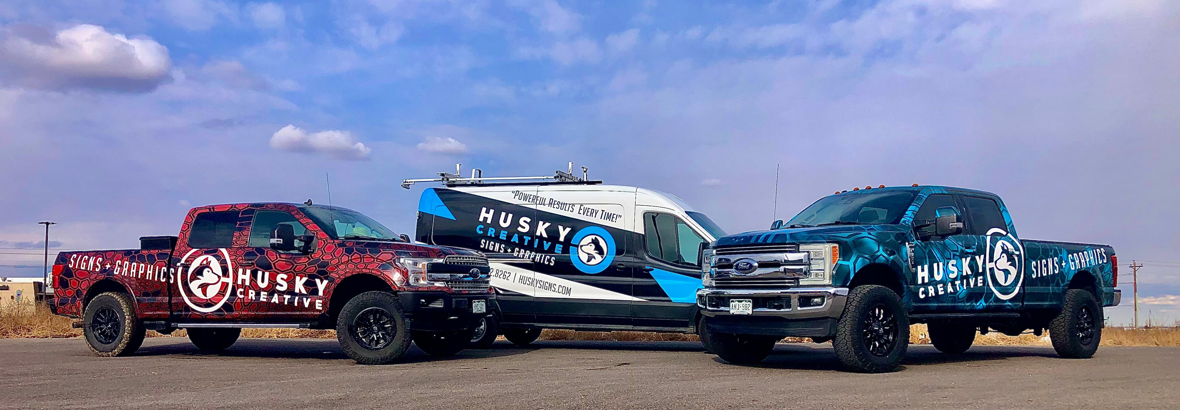 The complete fleet of Husky Signs, featuring the service van and the Colorado and Florida location trucks all wrapped in vinyl.