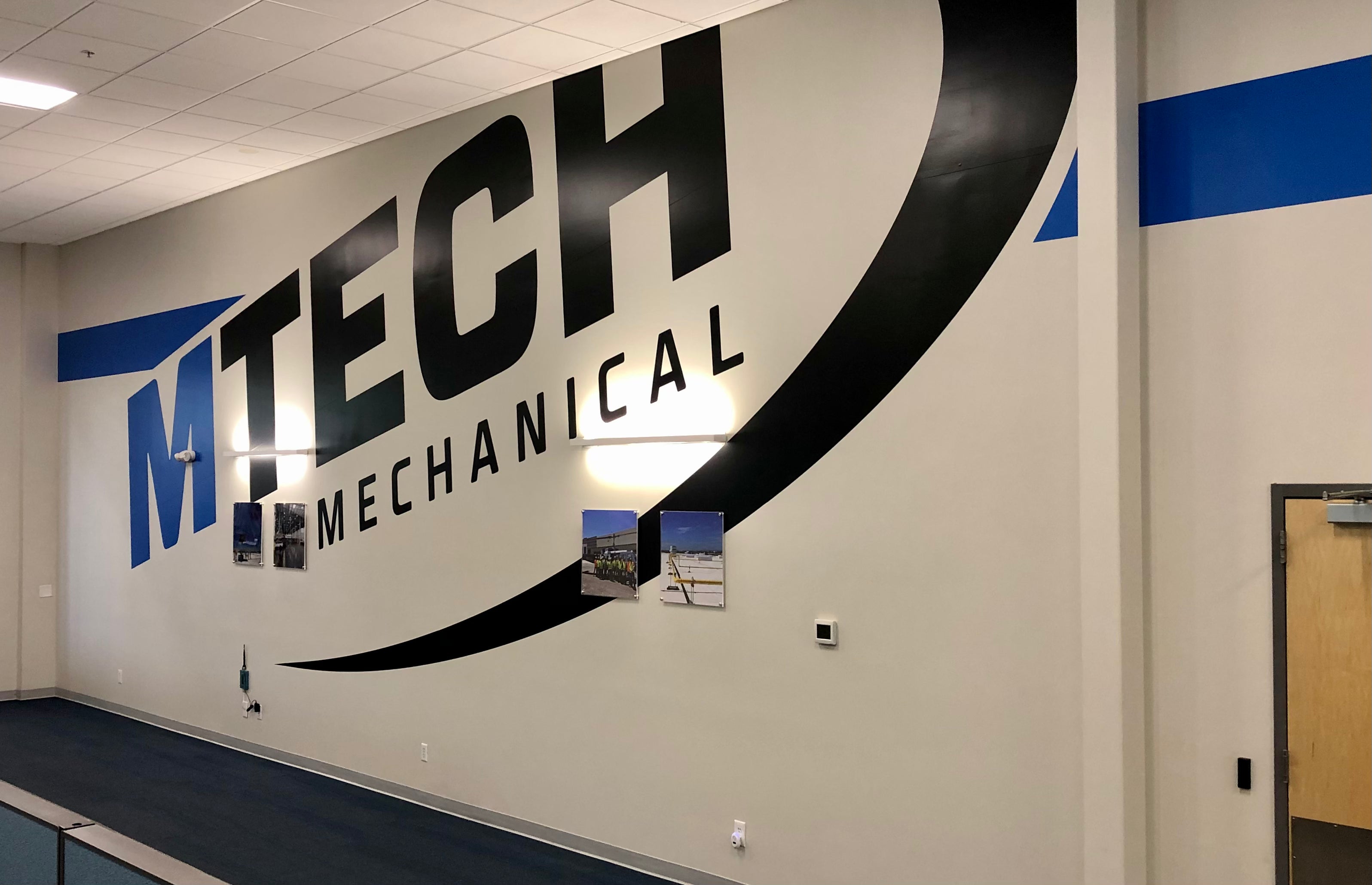 MTech Mechanical's large scale wall wrap, dominating their lobby's setting with an equally large logo centered upon a white background.