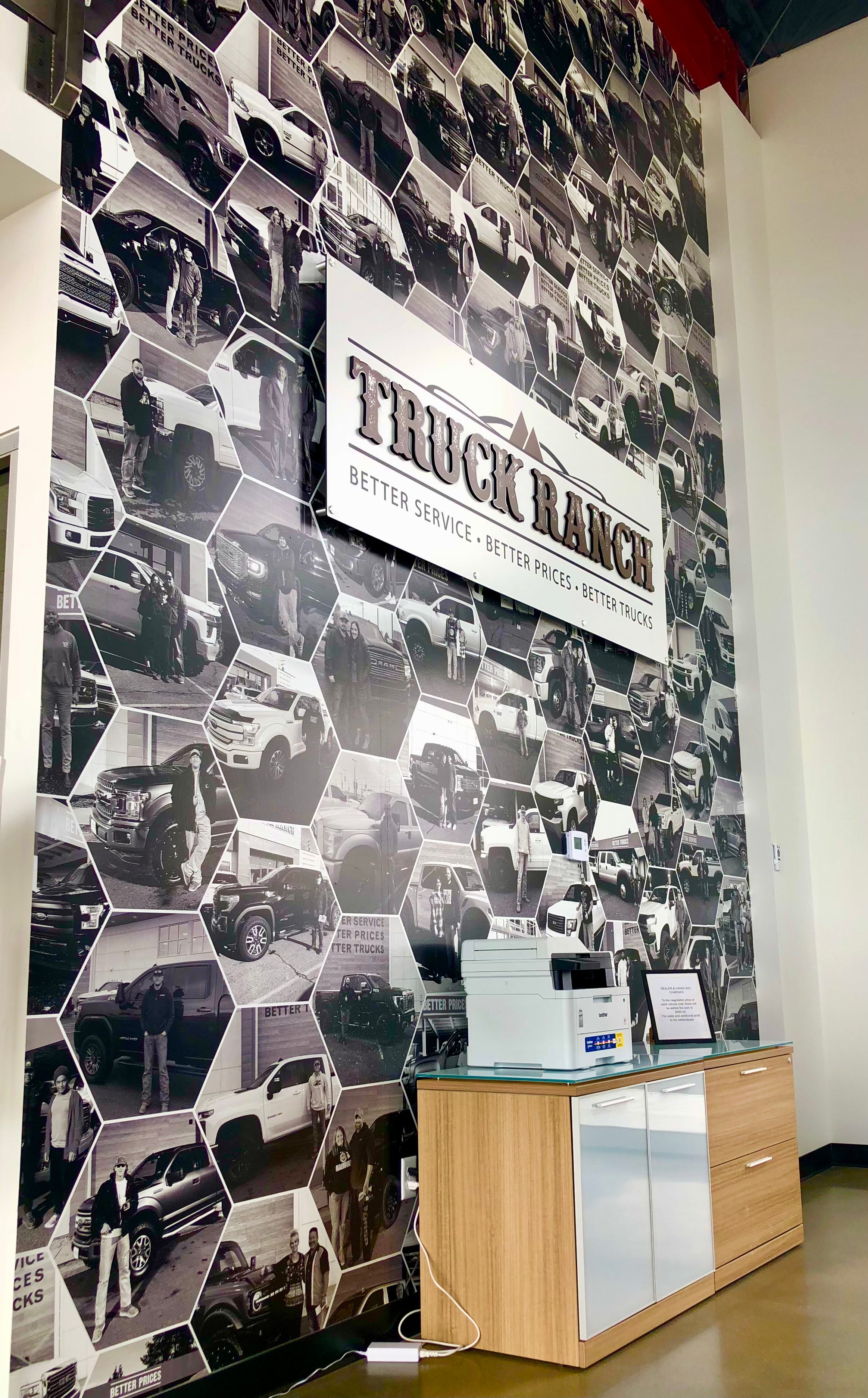 A wall wrap and sign for Truck Ranch in Frederick, Colorado. Featuring tons of photos of past projects and cars on the wrap and a professional sign on top to brand it all.