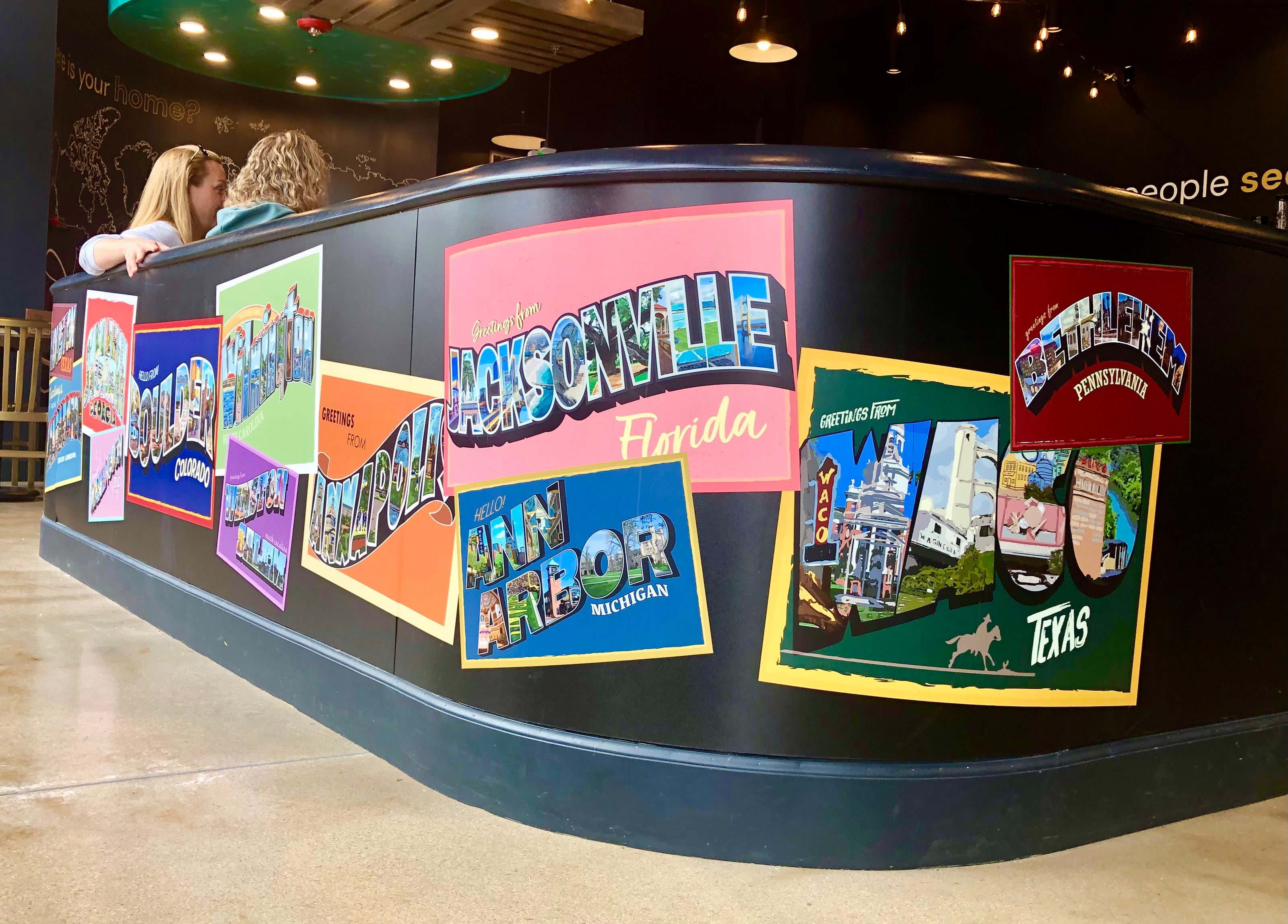 A custom wall wrap that showcases the postal stamps from around the United States.