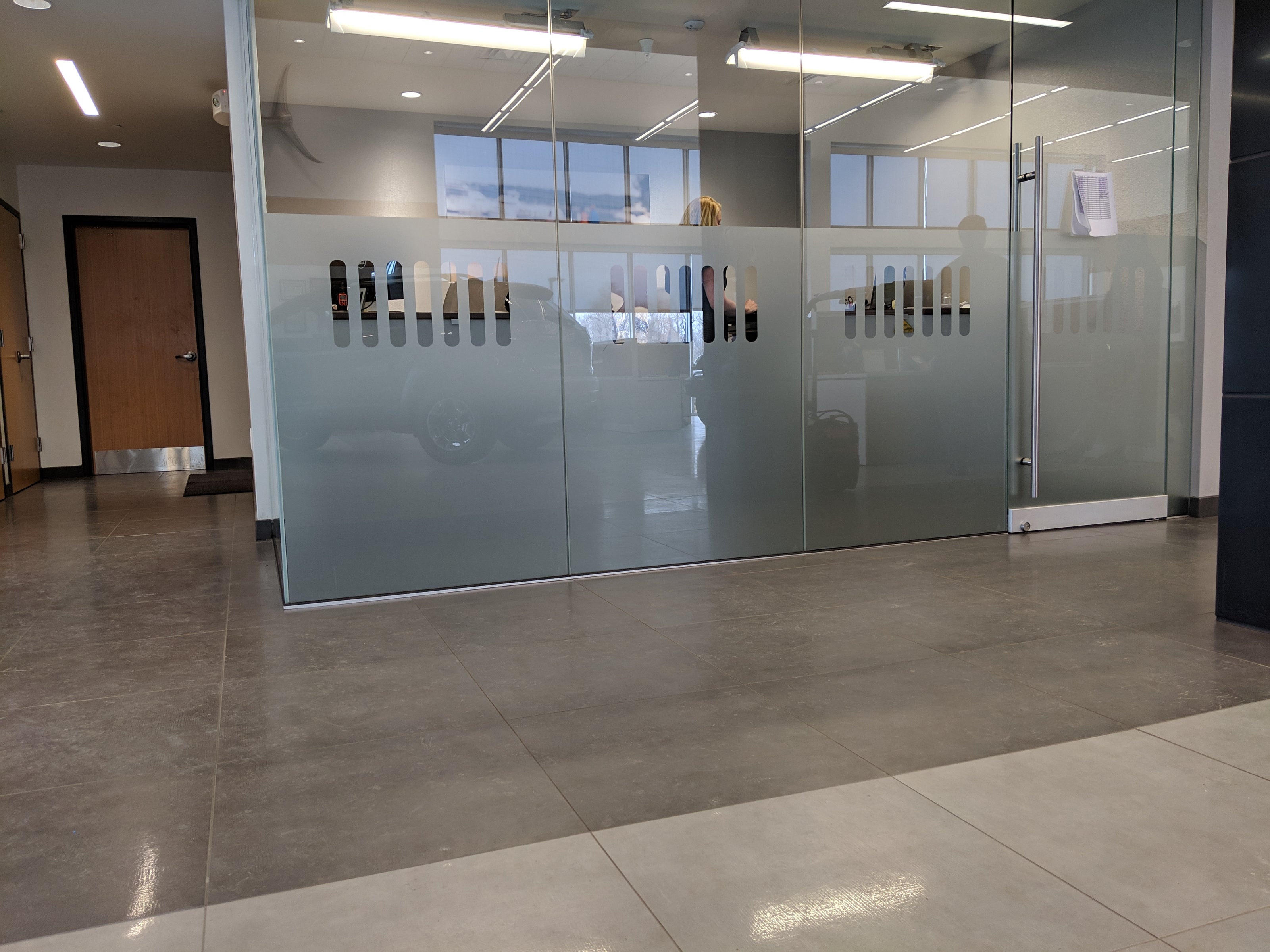 A sleek interior frosted window wrap installed in a business in Denver, Colorado. The design features a series of vertical rectangular shapes, providing privacy while maintaining a modern and professional look in the office environment.