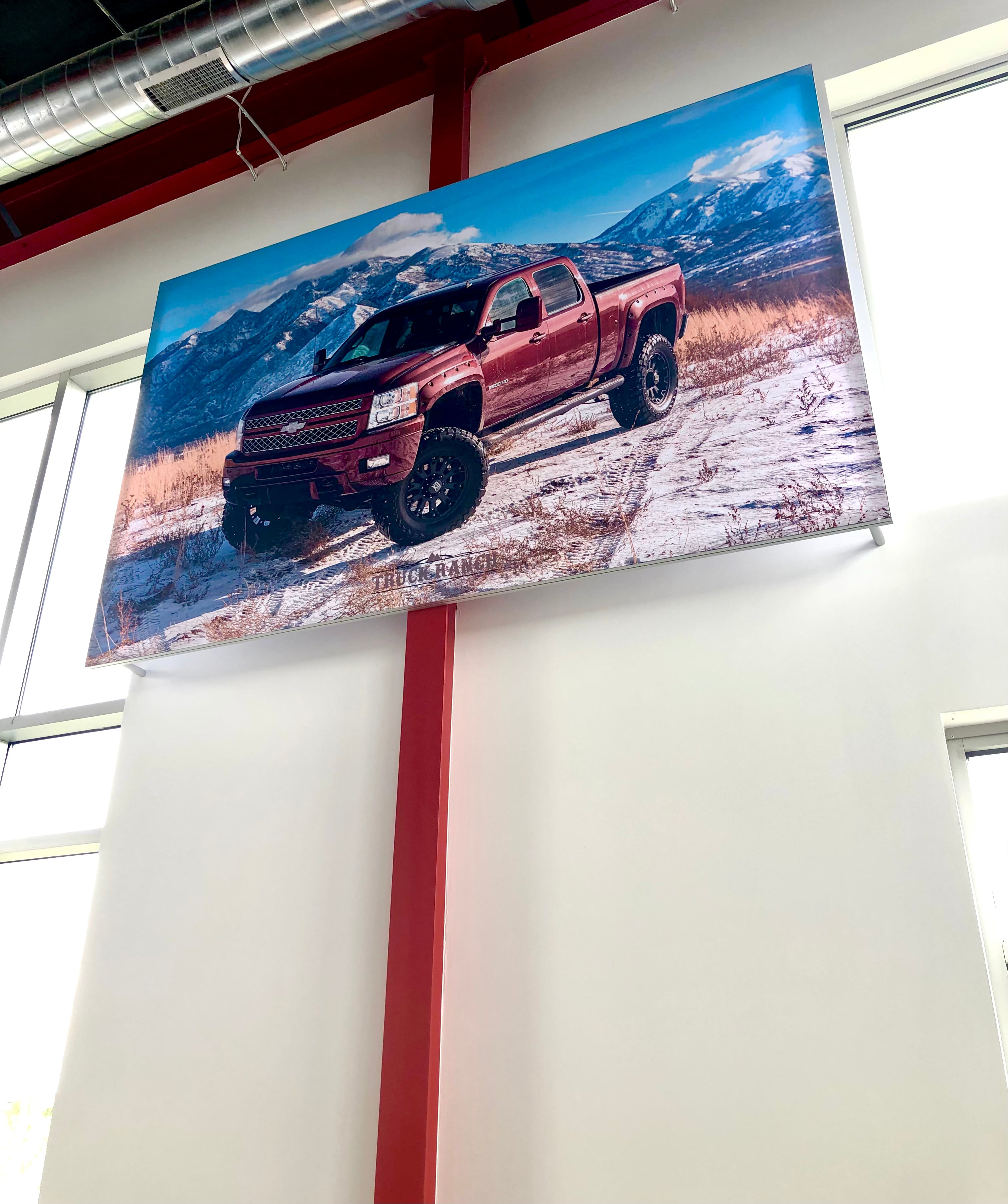 A wall-mounted fabric frame showing a Ford truck on a snowy hill in front of a snowy mountain range.