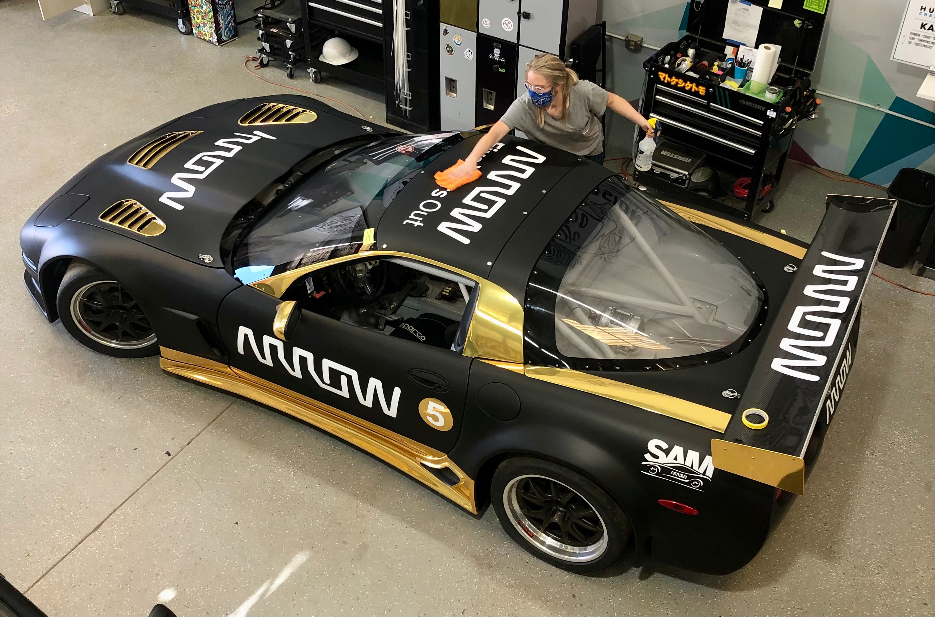Husky Signs' employee preforming the final wipe down on a vehicle vinyl wrap to guarantee a high quality install.
