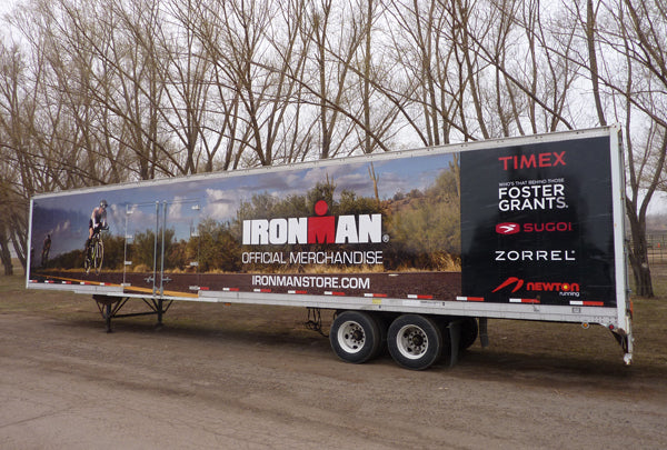 Full vehicle wrap on a trailer for 'Ironman,' showcasing dynamic branding and event imagery, based in Boulder, Colorado.