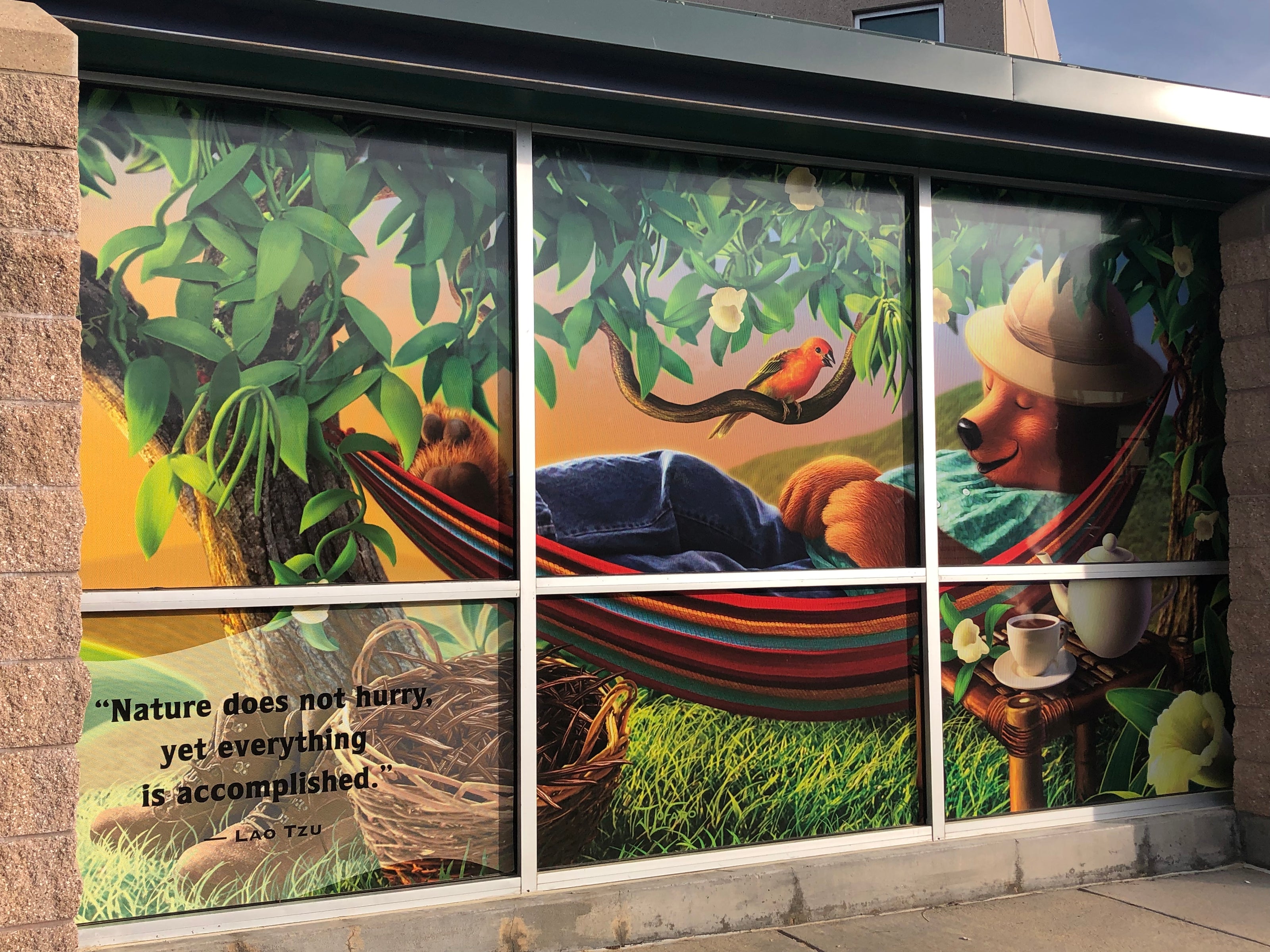 This image provides another perspective of the exterior window wrap at Celestial Seasonings in Boulder, Colorado. The design emphasizes the brand's natural themes with detailed artwork, contributing to the company's visual identity and enhancing the building’s exterior appeal.