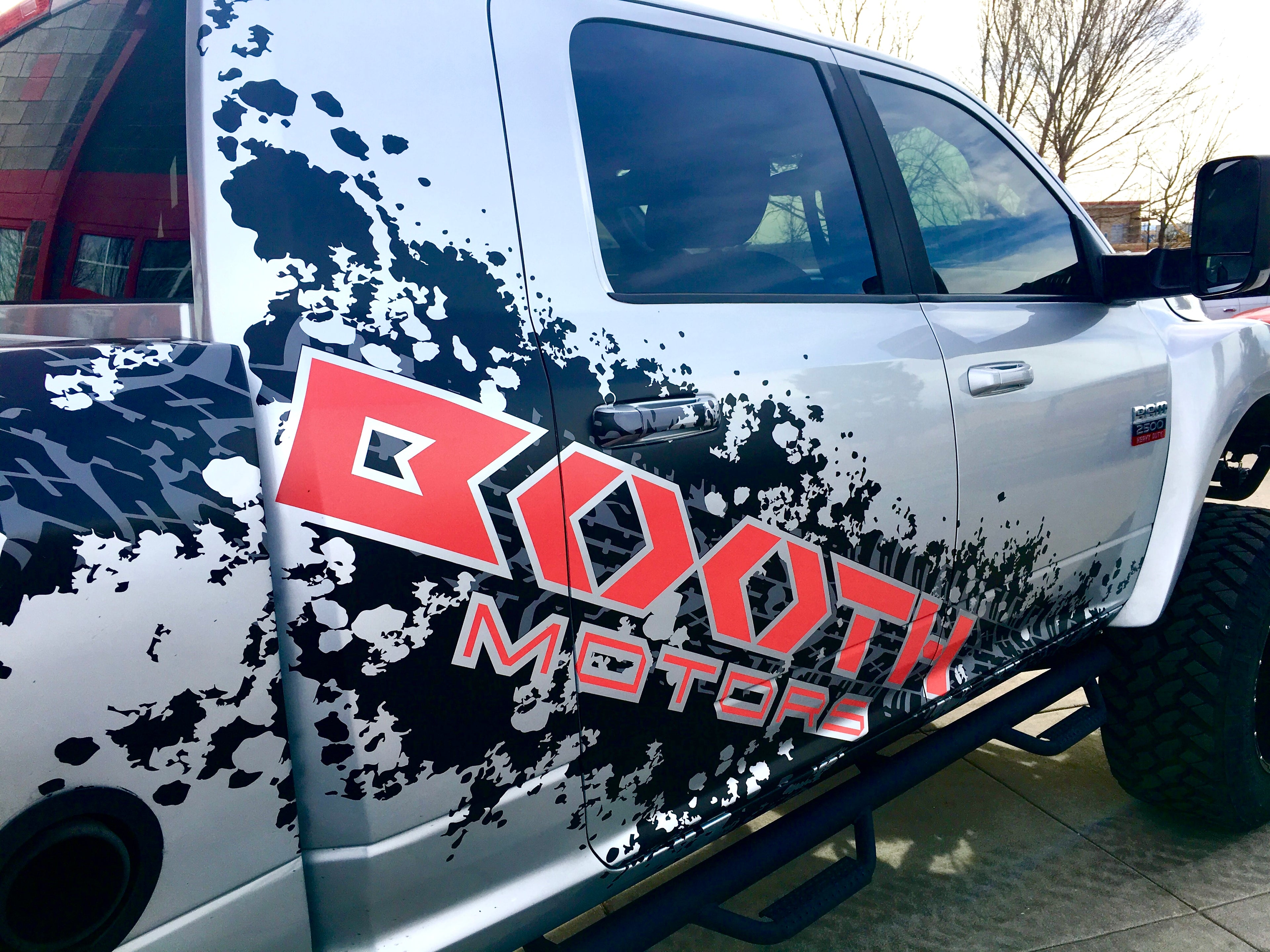 Picture of custom crafted vehicle truck vinyl wrap for Booth Motors in Longmont, Colorado by Husky Creative.